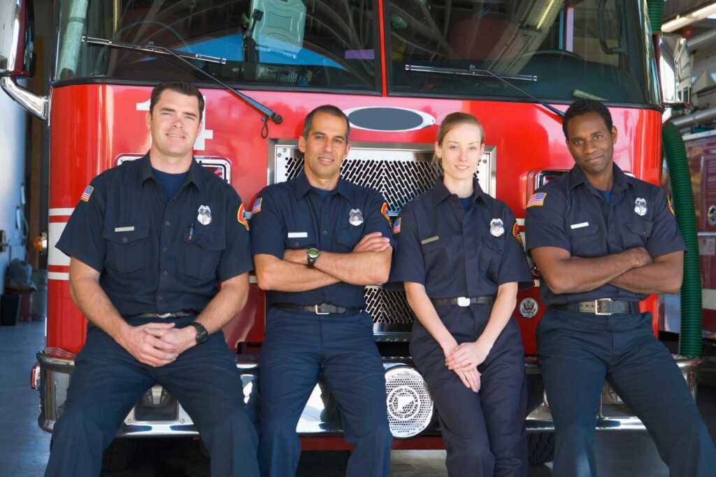 Firefighters sitting on the front of a fire engine