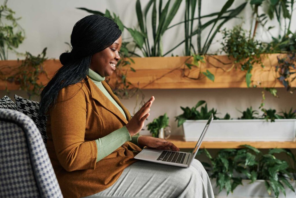 Woman using her laptop for a virtual burnout recovery coaching session
