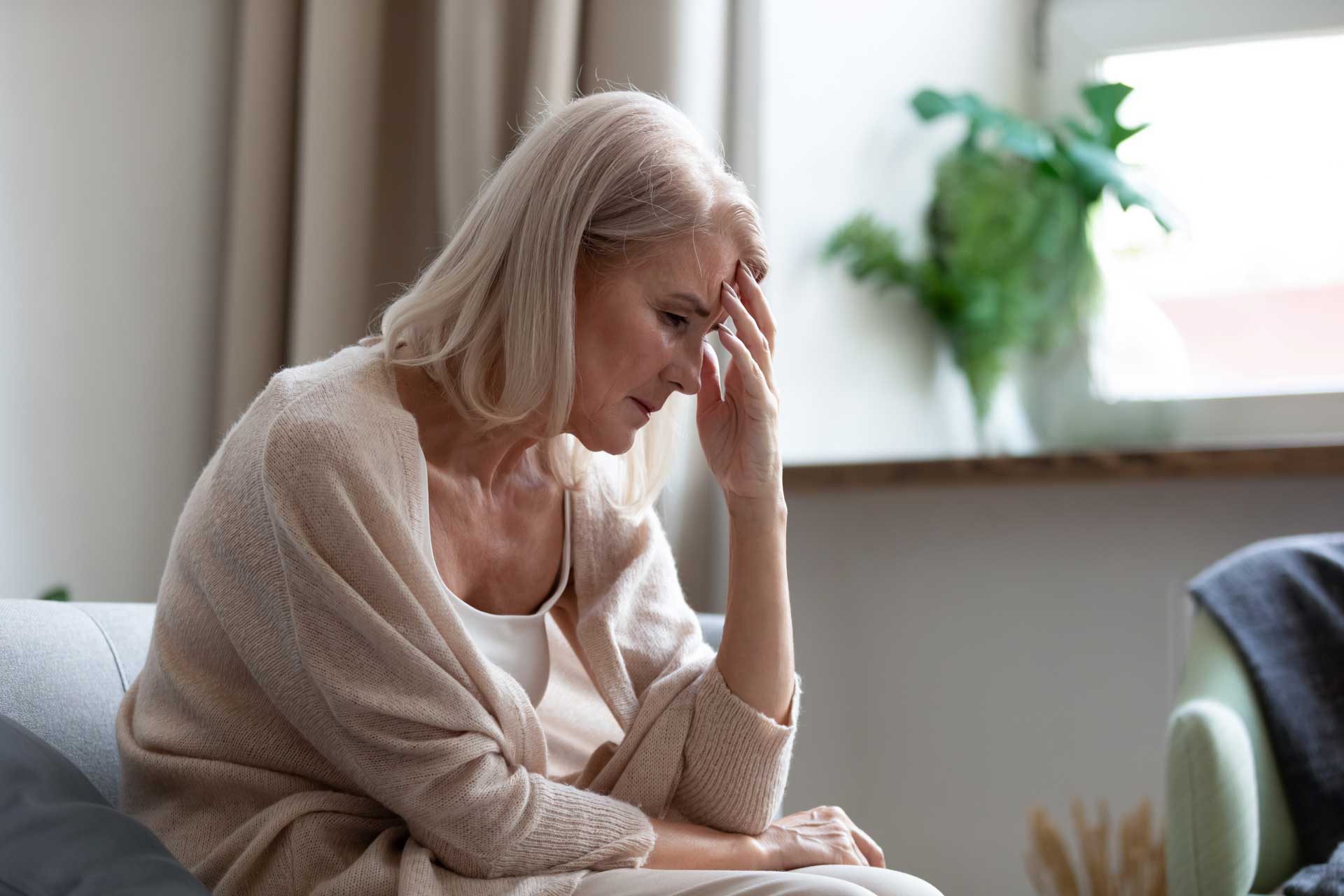 A depressed woman holding her face in her hand